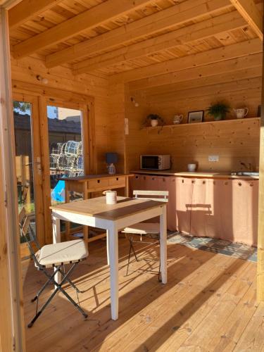 une cuisine avec une table et des chaises dans une cabine dans l'établissement Maison en bois 1 chambre 4 couchages type tiny house, à Granville