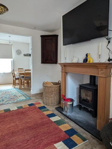 a living room with a fireplace with a flat screen tv above it at Georgian Terrace Town House in Mid Wales in Newtown