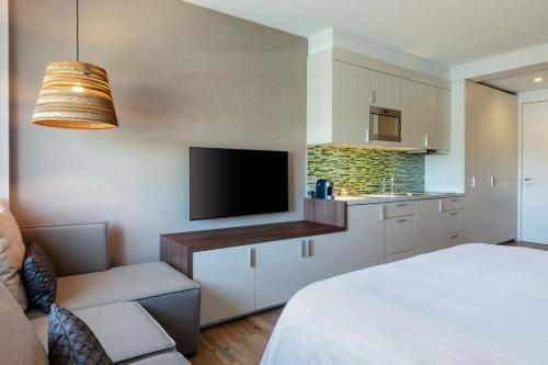 a room with a bed and a tv and a kitchen at Element Amsterdam in Amsterdam