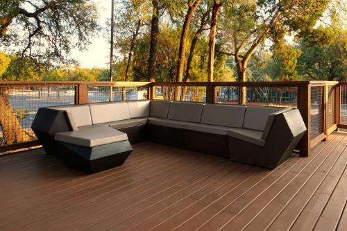 a couch sitting on a wooden deck with trees at SpringHill Suites by Marriott Austin The Domain Area in Austin