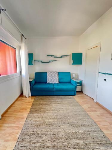a living room with a blue couch and a rug at Eurotel 405 in Rapallo
