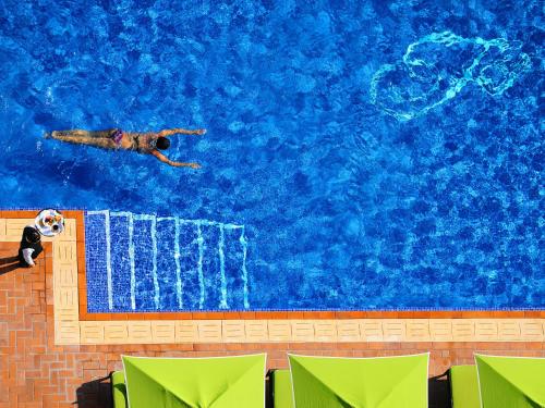 a person swimming in a swimming pool at Fraser Suites Seef Bahrain in Manama