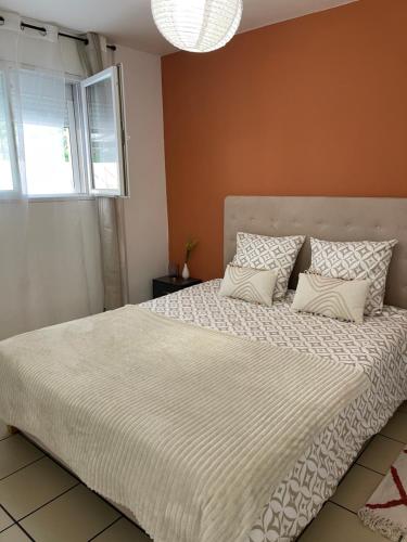 Un dormitorio con una cama grande con un edredón blanco. en Bali, en Saint-Martin-Lalande