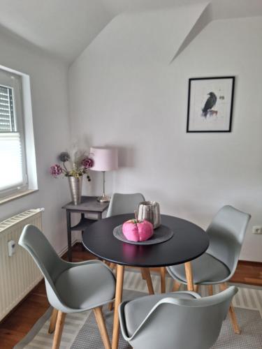 a dining room with a black table and chairs at Kleines Domizil am Südhang in Ortenberg