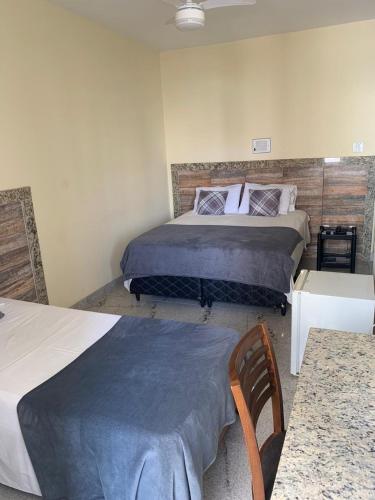 a bedroom with two beds and two tables in it at Alvorada Palace Hotel de Poços in Poços de Caldas