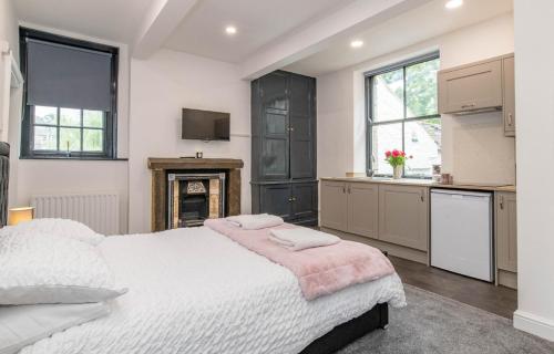a bedroom with a large bed and a kitchen at Mill Bridge in Skipton
