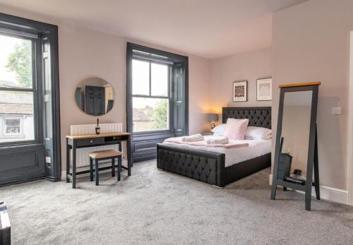a bedroom with a bed and a mirror and a vanity at Mill Bridge in Skipton