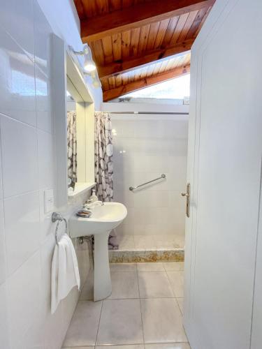 a white bathroom with a sink and a shower at Pino Dorado in Punta del Este