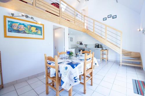 une salle à manger avec une table et un escalier dans l'établissement Goul Ar Roz I Terrasse sud & Vue mer, à Telgruc-sur-Mer