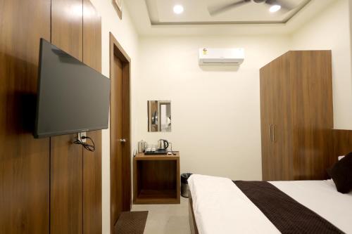 a bedroom with a bed and a flat screen tv at Hotel Shrinath Palace in Mathura