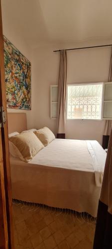 a bedroom with a large bed with a window at Dar Inès in Tangier