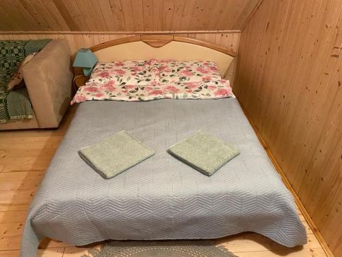 a bed in a tiny house with two pillows on it at Agroturystyka Szczebra 33c Dolina Rospudy pod Augustowem, Apartamenty 2-pokojowe z aneksami kuchennymi in Augustów