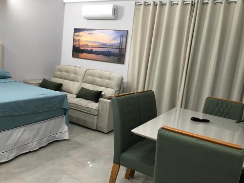 a living room with a couch and a table at Valentina 24 HORAS in Florianópolis