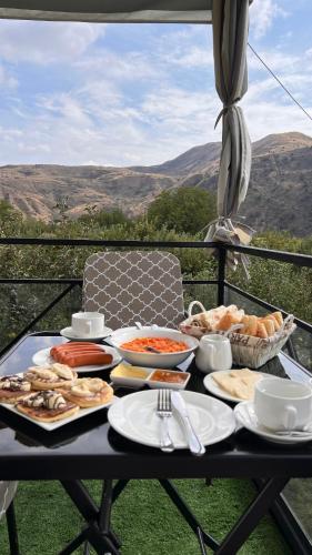 a table with food on it with a view of mountains at Hidden Garden Resort in Garni