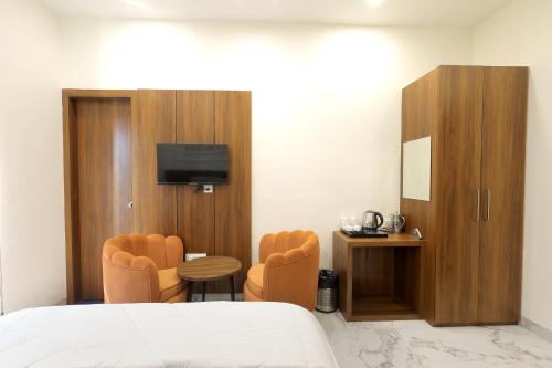 a hotel room with a bed and a table and chairs at Hotel Shrinath Palace in Mathura