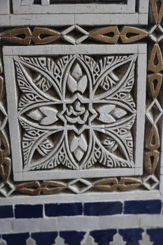 a stone wall with a flower design on it at Riad Batchisarai in Fès