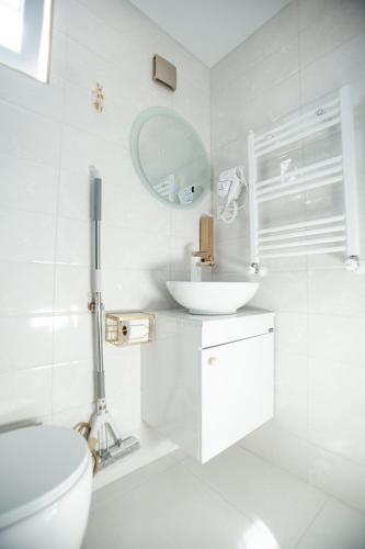 a white bathroom with a toilet and a sink at Golden Palace in Kutaisi