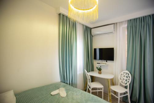 a bedroom with a bed and a table with chairs at Golden Palace in Kutaisi
