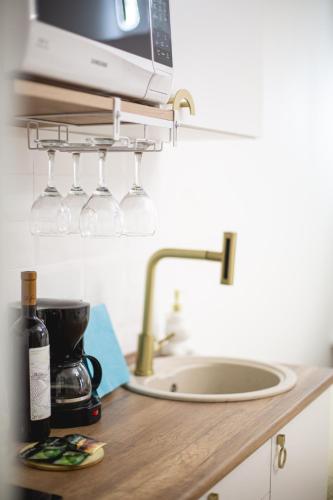 a kitchen counter with wine glasses and a sink at Golden Palace in Kutaisi
