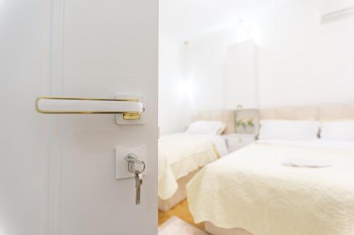 a room with two beds and a door with a key at Golden Palace in Kutaisi
