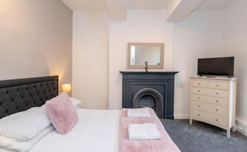 a bedroom with a bed with a fireplace and a television at Mill Bridge in Skipton