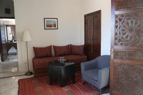 a living room with a couch and a chair at Riad Batchisarai in Fès