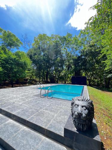 a lion statue sitting next to a swimming pool at Wildescape Polonnaruwa in Polonnaruwa