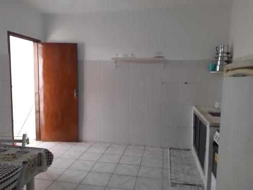 a kitchen with a door and a tiled floor at Casa a 270 metros da basilica in Aparecida