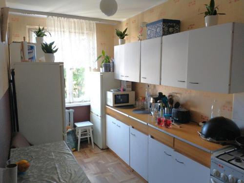 a kitchen with white cabinets and a counter top at Słoneczny Pokój w bloku na 1 p dla 1 Niepalącej Osoby od 1 do 12 miesięcy in Kraków