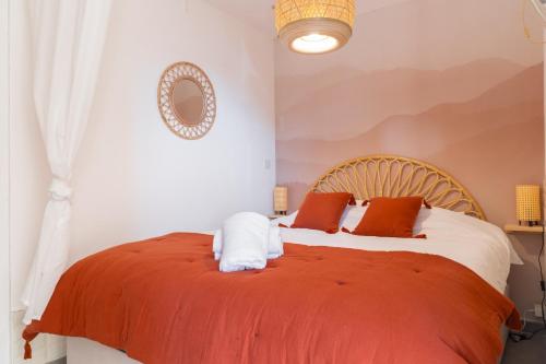 une chambre avec un lit avec une couverture orange dans l'établissement Appart proche plage, piscine, clim, parking privé - arrivée autonome - lit queen size, à La Seyne-sur-Mer