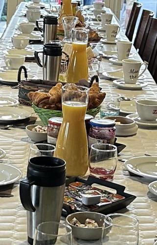 a long table with plates of food and drinks on it at ABEL Hôtel CHAMBRE ECONOMIQUE PARKING PRIVE WIFI in Langeac