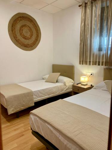 a hotel room with two beds and a window at A R Benjamín in Artana