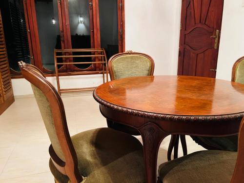 a wooden table and chairs in a room at Twenty- Two Swiss Residence in Weligama