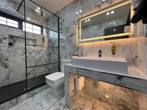 a bathroom with a sink and a toilet and a mirror at Urban Escape 4BedRoom House- With Free private Parking - Birmingham City in Birmingham