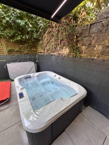 a jacuzzi tub sitting on a patio at Petit studio et son spa abrité in Nancy