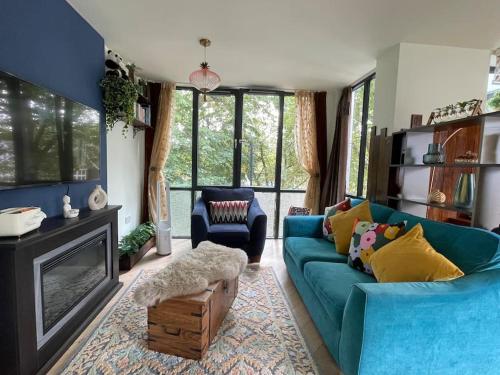 a living room with a blue couch and a fireplace at The Urban Green! Cosy luxury apartment in Chiswick in London