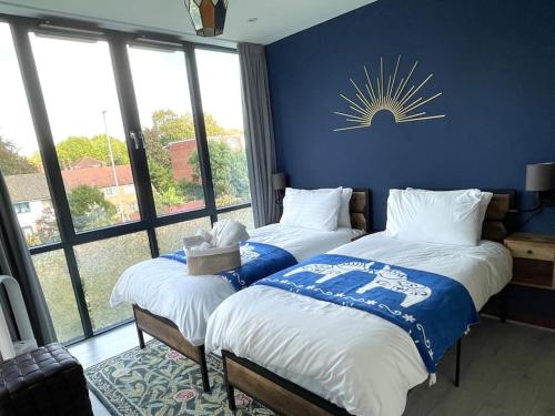 two beds in a room with a sun on the wall at The Urban Green! Cosy luxury apartment in Chiswick in London