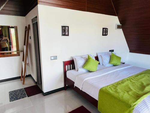 a bedroom with a bed with green and white pillows at Cloudy Hill Cottage in Ella