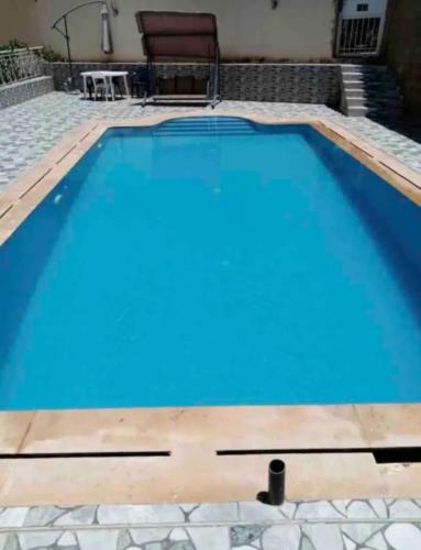 a swimming pool with blue water in a house at Appartement villa Meknès in Meknès