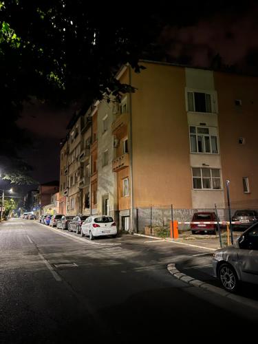 a street with cars parked in front of a building at AQUA Apartment in Belgrade