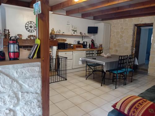 une cuisine et une salle à manger avec une table et des chaises dans l'établissement Location Thezacaise, à Thézac