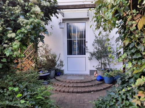 a front door of a white house with plants at Ferienwohnung mit maritimen Flair in Lohme