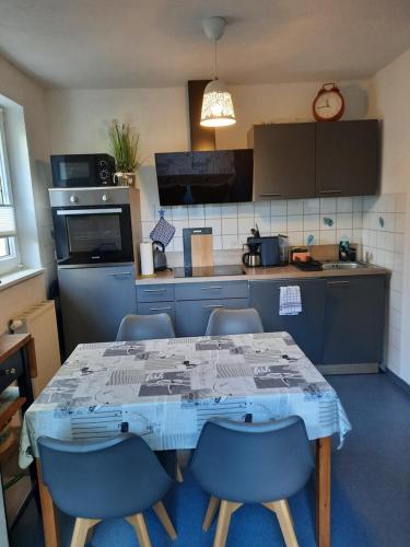 a kitchen with a table and some chairs and a table and a kitchen at Ferienwohnung mit maritimen Flair in Lohme