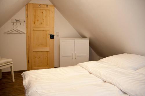 a bedroom with a white bed and an open door at Ilmhaus in Pförring