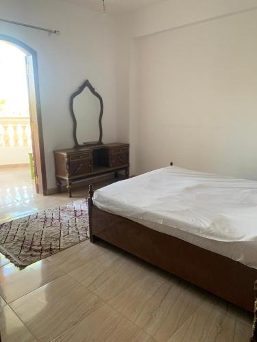 a bedroom with a bed and a dresser and a window at Villa Elhag Nile View in Luxor