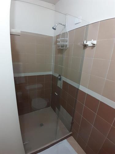a shower with a glass door in a bathroom at Selvática Alojamiento Eco in Medellín