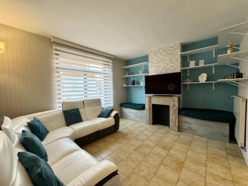 ein Wohnzimmer mit einer weißen Couch und einem Kamin in der Unterkunft Le Cocon de Karine - maison Boulogne Sur Mer in Saint-Martin-Boulogne