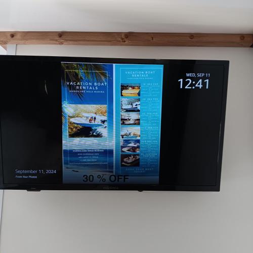 a television screen with two posters on it at Aqua Lodges At Hurricane Hole Marina in Key West