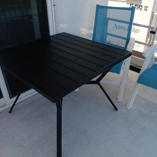 a black table next to a blue chair at Aqua Lodges At Hurricane Hole Marina in Key West
