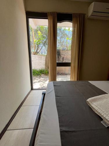 a bedroom with a bed and a large window at Hotel Mirador del Dayman in Termas del Daymán